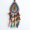 Caça-Sonhos 7 Chakras Artesanal - Equilíbrio Energético e Proteção de Bali​: Transforme a energia do seu espaço e garanta um sono reparador e protegido com este exclusivo Caça-Sonhos 7 Chakras. Uma peça que transcende a decoração: é um poderoso portal de cura energética, alinhamento e proteção espiritual.✨ Características Místicas e Artesanais​: Artesanato Esotérico de Bali: Cuidadosamente feito à mão por artesãos locais na Ilha dos Deuses, Bali (Indonésia), capturando a essência da espiritualidade insular e da arte balinesa.Teia de Proteção Energética: O intrincado padrão de renda no centro funciona como uma teia mística onde os pesadelos e as energias densas são presos, permitindo que apenas os sonhos positivos e a inspiração passem.Alinhamento dos 7 Chakras: O elemento central apresenta as 7 cores dos chakras principais (Raiz, Sacral, Plexo Solar, Cardíaco, Laríngeo, Terceiro Olho e Coroa). Esta incorporação confere-lhe um propósito ativo de cura e harmonização, atuando no seu campo energético enquanto dorme ou medita.Vibração e Leveza: Composto por múltiplas camadas de penas multicoloridas, este amuleto de proteção cria um efeito visual deslumbrante que simboliza a leveza da alma e a liberdade espiritual.🧘 O Poder Esotérico do Caça-Sonhos (Dreamcatcher) é um amuleto tradicional essencial para quem busca a proteção noturna:​ Filtro de Sonhos: A teia apanha as energias negativas da noite, que são purificadas pela luz da manhã, garantindo que apenas as visões positivas e inspiradoras cheguem até si, escorregando suavemente pelas penas.​ Cura e Equilíbrio Energético: Além da proteção, este Dreamcatcher com as cores dos Chakras promove ativamente o alinhamento dos pontos de energia, fomentando a saúde física, emocional e espiritual.​ Decoração Consciente: Perfeito para ser o ponto focal no seu quarto, espaço de meditação, altar ou qualquer canto que necessite de uma elevação de energia e um toque de vibração positiva.Traga a magia de Bali e a sabedoria dos Chakras para a sua vida. Invista em noites de sono reparadoras e na harmonia energética do seu lar!