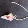 Pêndulo de Quartzo Rosa e 7 Chakras - Radiestesia, Amor e Equilíbrio Energético Eleve sua prática radiestésica e harmonize seu campo vibracional com este deslumbrante Pêndulo de Cura, uma ferramenta esotérica poderosa que combina a energia do Amor Incondicional do Quartzo Rosa com o alinhamento completo dos seus centros energéticos. 💎 A Força do Quartzo Rosa para Radiestesia Este pêndulo é meticulosamente esculpido em Quartzo Rosa natural, a pedra do amor, paz e cura emocional. Propriedades de Cura: Atua diretamente no Chakra Cardíaco, acalmando o sistema nervoso e promovendo a autoestima, a aceitação e a abertura para receber e dar amor. Vibração Ideal: Sua energia suave e compassiva é perfeita para radiestesistas que buscam sensibilidade e empatia em seus trabalhos. Aplicações Terapêuticas: Ideal para detecção de padrões energéticos em relacionamentos, localização de bloqueios emocionais e medição da vibração de ambientes para promover harmonia e bem-estar. 🌈 O Toque dos 7 Chakras: Multiplicador de Energia O pêndulo é ricamente adornado na sua corrente com pequenas pedras naturais representando os sete principais chakras. Esta adição é fundamental para potencializar sua prática de cura energética: Equilíbrio e Neutralidade: Cada pedra (representando os chakras Raiz ao Coroa) atua como um multiplicador de energia, garantindo que o instrumento de radiestesia opere a partir de um estado de equilíbrio vibracional e neutralidade completa. Foco e Precisão: Ajuda o operador a manter a conexão intuitiva com todos os seus centros de energia durante a consulta, resultando em respostas intuitivas mais claras e precisas. Adquira o Seu! Este pêndulo divinatório é um instrumento de trabalho que une a beleza da natureza à potência energética necessária para suas investigações. Perfeito para quem busca respostas intuitivas ancoradas no amor e na harmonia. Leve o equilíbrio dos chakras e a suavidade do Quartzo Rosa para a sua mesa de trabalho esotérica!