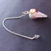 Pêndulo de Quartzo Rosa e 7 Chakras - Radiestesia, Amor e Equilíbrio Energético Eleve sua prática radiestésica e harmonize seu campo vibracional com este deslumbrante Pêndulo de Cura, uma ferramenta esotérica poderosa que combina a energia do Amor Incondicional do Quartzo Rosa com o alinhamento completo dos seus centros energéticos. 💎 A Força do Quartzo Rosa para Radiestesia Este pêndulo é meticulosamente esculpido em Quartzo Rosa natural, a pedra do amor, paz e cura emocional. Propriedades de Cura: Atua diretamente no Chakra Cardíaco, acalmando o sistema nervoso e promovendo a autoestima, a aceitação e a abertura para receber e dar amor. Vibração Ideal: Sua energia suave e compassiva é perfeita para radiestesistas que buscam sensibilidade e empatia em seus trabalhos. Aplicações Terapêuticas: Ideal para detecção de padrões energéticos em relacionamentos, localização de bloqueios emocionais e medição da vibração de ambientes para promover harmonia e bem-estar. 🌈 O Toque dos 7 Chakras: Multiplicador de Energia O pêndulo é ricamente adornado na sua corrente com pequenas pedras naturais representando os sete principais chakras. Esta adição é fundamental para potencializar sua prática de cura energética: Equilíbrio e Neutralidade: Cada pedra (representando os chakras Raiz ao Coroa) atua como um multiplicador de energia, garantindo que o instrumento de radiestesia opere a partir de um estado de equilíbrio vibracional e neutralidade completa. Foco e Precisão: Ajuda o operador a manter a conexão intuitiva com todos os seus centros de energia durante a consulta, resultando em respostas intuitivas mais claras e precisas. Adquira o Seu! Este pêndulo divinatório é um instrumento de trabalho que une a beleza da natureza à potência energética necessária para suas investigações. Perfeito para quem busca respostas intuitivas ancoradas no amor e na harmonia. Leve o equilíbrio dos chakras e a suavidade do Quartzo Rosa para a sua mesa de trabalho esotérica!