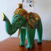 Escultura Elefante Madeira Bali Artesanal | Dourado e Turquesa | Decoração Asiática Étnica Adicione um toque de sabedoria e exotismo à sua decoração com esta manífica escultura de elefante em madeira. Cada peça é esculpida à mão por mestres artesãos na ilha paradisíaca de Bali, na Indonésia, garantindo um artigo único e cheio de carácter! Características Principais: Artesanato Autêntico de Bali: Esta escultura é o resultado de técnicas tradicionais de entalhe em madeira, passadas de geração em geração. Design Exclusivo: O acabamento em tons vibrantes do dourado e turquesa conferem um charme especial, combinando a riqueza cultural com um toque moderno.Simbolismo de Sorte e Sabedoria: Na cultura asiática, o elefante é um animal sagrado, símbolo de sorte, prosperidade e sabedoria. Material Natural: Feita a partir de madeira sustentável (madeira de Albésia, leve e durável), esta elegante peça é ecológica e robusta. Decoração Étnica e Zen: Perfeita para criar um ambiente Zen, étnico ou para adicionar um ponto focal de cor em qualquer divisão da sua casa, escritório ou espaço de meditação. Ideal Para:Amantes de artesanato e decoração asiática ou étnica. Quem procura um amuleto de boa sorte e prosperidade para o seu lar. Prendas únicas com significado!Nota: Por se tratar de um produto artesanal, pequenas variações nas cores e nos detalhes podem ocorrer, o que torna a sua peça verdadeiramente exclusiva. e com significado!Nota: Por se tratar de um produto artesanal, pequenas variações nas cores e nos detalhes podem ocorrer, o que torna a sua peça verdadeiramente exclusiva.