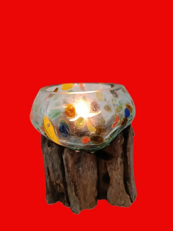 Peça de arte em Vidro Reciclado Colorido e Madeira de Bali: Uma Fusão Natural e Única Descubra a magia da natureza e do fogo capturada numa só peça! Apresentamos uma espetacular escultura composta por vidro colorido e fundido em madeira que é uma verdadeira obra de arte artesanal de Bali. Esta criação única é o resultado de um processo manual fascinante: o vidro reciclado é fundido e moldado enquanto quente para se adaptar perfeitamente à forma orgânica da madeira natural (frequentemente madeira de teca ou gamal). O resultado é uma justaposição hipnotizante de texturas — a suavidade do vidro derretido contrasta com o calor rústico da madeira. Artesanato Genuíno de Bali: Cada peça é feita à mão por talentosos artesãos na Indonésia. O processo garante que não existem duas peças iguais. Design Único e Orgânico: O vidro flui livremente sobre a madeira, criando um recipiente ou arranjo escultural exclusivo que se adapta perfeitamente a qualquer estilo de decoração — do rústico ao moderno ou Zen. Tamanho Médio Versátil: Ideal como centro de mesa, porta velas, terrário para suculentas, ou simplesmente como um objeto de decoração por si só. Sustentabilidade: Uma peça ecológica, que utiliza vidro reciclado e madeira local de origem sustentável. Porquê Comprar Esta Peça? Esta não é apenas uma peça de decoração; é um pedaço da Alma de Bali. Ao adquirir esta escultura, está a levar para casa um objeto que celebra a imperfeição natural e o génio criativo humano. É a escolha perfeita para quem procura um presente original e com significado! Não perca a oportunidade de possuir esta fusão hipnotizante de elementos naturais. Devido à sua natureza artesanal e exclusiva, o stock é limitado.