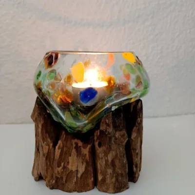 Peça de arte em Vidro Reciclado Colorido e Madeira de Bali: Uma Fusão Natural e Única Descubra a magia da natureza e do fogo capturada numa só peça! Apresentamos uma espetacular escultura composta por vidro colorido e fundido em madeira que é uma verdadeira obra de arte artesanal de Bali. Esta criação única é o resultado de um processo manual fascinante: o vidro reciclado é fundido e moldado enquanto quente para se adaptar perfeitamente à forma orgânica da madeira natural (frequentemente madeira de teca ou gamal). O resultado é uma justaposição hipnotizante de texturas — a suavidade do vidro derretido contrasta com o calor rústico da madeira. Artesanato Genuíno de Bali: Cada peça é feita à mão por talentosos artesãos na Indonésia. O processo garante que não existem duas peças iguais. Design Único e Orgânico: O vidro flui livremente sobre a madeira, criando um recipiente ou arranjo escultural exclusivo que se adapta perfeitamente a qualquer estilo de decoração — do rústico ao moderno ou Zen. Tamanho Médio Versátil: Ideal como centro de mesa, porta velas, terrário para suculentas, ou simplesmente como um objeto de decoração por si só. Sustentabilidade: Uma peça ecológica, que utiliza vidro reciclado e madeira local de origem sustentável. Porquê Comprar Esta Peça? Esta não é apenas uma peça de decoração; é um pedaço da Alma de Bali. Ao adquirir esta escultura, está a levar para casa um objeto que celebra a imperfeição natural e o génio criativo humano. É a escolha perfeita para quem procura um presente original e com significado! Não perca a oportunidade de possuir esta fusão hipnotizante de elementos naturais. Devido à sua natureza artesanal e exclusiva, o stock é limitado.
