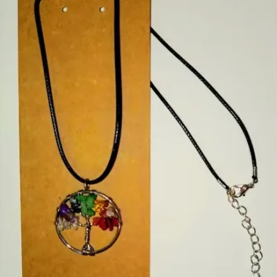 Colar Árvore da Vida com Pedras dos 7 Chakras: Equilíbrio e Conexão Procura uma peça que una beleza, proteção e alinhamento espiritual? O nosso Colar Árvore da Vida com os 7 Chakras é mais do que um acessório, é um amuleto poderoso concebido para harmonizar a sua energia vital enquanto exalta o seu estilo pessoal! A Simbologia da Árvore da Vida A Árvore da Vida é um dos símbolos mais sagrados.  Representa a nossa ligação entre o céu e a terra, o crescimento espiritual e a imortalidade. Ao usar este colar, estará a celebrar a sua própria jornada de evolução e a força das suas raízes! O Poder dos 7 Chakras Nesta peça artesanal, cada ramo da árvore é adornado com cristais autênticos que correspondem aos centros energéticos do corpo: Chakra Raiz: Estabilidade e segurança. Chakra Sacral: Criatividade e vitalidade. Chakra Plexo Solar: Confiança e poder pessoal. Chakra do Coração: Amor e cura emocional. Chakra da Garganta: Comunicação e verdade. Chakra do Terceiro Olho: Intuição e sabedoria. Chakra da Coroa ou Coronário: Conexão espiritual e luz.Por que escolher o nosso Colar Artesanal? Feito à Mão: Cada colar é produzido de forma artesanal, garantindo que recebe uma peça única, carregada de intenção positiva. Feito na Índia por artesãos de tradição ancestral. Cristais Naturais: Utilizamos apenas pedras e cristais autênticos para garantir que beneficia das propriedades terapêuticas da cristaloterapia. Design Intemporal: Um acessório versátil que combina com qualquer look, do casual ao elegante, ideal para quem não abdica da Sua Essência devotada ao esoterismo. Presente com Significado: É a escolha perfeita para oferecer a alguém especial que valoriza o bem-estar, a meditação e o autoconhecimento. Benefícios de Usar este Colar: Ajuda no alinhamento dos chakras durante o dia a dia. Fomenta a paz interior e a proteção contra energias negativas. Promove o foco durante práticas de Yoga e Meditação. Adquira a sua peça de harmonia hoje mesmo! Não deixe que o stress do dia-a-dia bloqueie a sua energia! Sinta a vibração dos cristais dos 7 chakras e a força da natureza, junto ao seu peito. Basta adicionar ao seu carrinho aqui na Loja OM! Nota: Por ser um artigo de artesanato com pedras naturais, cada colar possui variações únicas de cor e forma, tornando a sua peça exclusivamente sua.