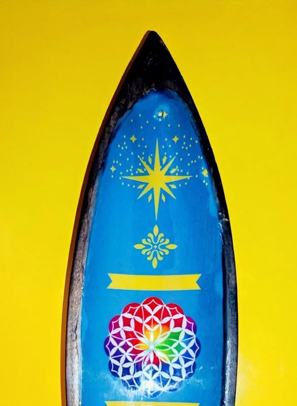 O Equilíbrio Perfeito entre Arte e Espiritualidade: Este não é apenas um lindo porta-incensos, é um objeto de decoração zen desenhado para elevar a vibração do seu altar ou espaço de meditação. O detalhe central da mandala esmaltada não só embeleza o ambiente, como serve de foco visual para práticas de concentração e alinhamento energético. Porquê escolher este Suporte de Incensos de Madeira de Manga? Autenticidade Handmade: Por ser um artigo feito à mão, cada suporte possui veios e detalhes únicos na madeira, garantindo que terá uma peça exclusiva no mundo! Sustentabilidade: A madeira de manga é reconhecida pela sua durabilidade e por ser uma escolha amiga do ambiente no mundo do artesanato esotérico. Design Funcional: O formato longo é ideal para recolher as cinzas das varetas de incenso de forma limpa e segura, protegendo os seus móveis. Pode queimar duas varetas de incensos em simultâneo. Estética Boho-Chic: O acabamento esmaltado vibrante contrasta com o rústico da madeira, adaptando-se perfeitamente a qualquer estilo de decoração mística. Ideal para os seus Rituais de Bem-Estar Seja para uma sessão de Yoga, uma limpeza com Palo Santo ou simplesmente para perfumar a casa, este suporte é o acessório essencial! A simbologia da Mandala no centro ajuda a irradiar harmonia e equilíbrio, tornando as suas práticas de limpeza energética muito mais profundas. Dica Espiritual: Utilize este suporte no seu cantinho de leitura ou trabalho para manter a energia fluida e o foco elevado através da aromaterapia. Especificações: Material: Madeira de Manga de alta qualidade com detalhe esmaltado. Origem: Importado da Índia (Trabalho artesanal). Uso: Compatível com incensos em vareta tradicionais. Não deixe jamais a sua energia estagnar! Traga um pedaço da sabedoria Indiana para o seu lar e sinta a diferença da vibração energética no seu ambiente. Adicionar ao carrinho